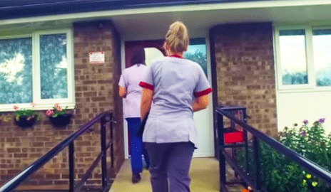 Care workers approaching a house
