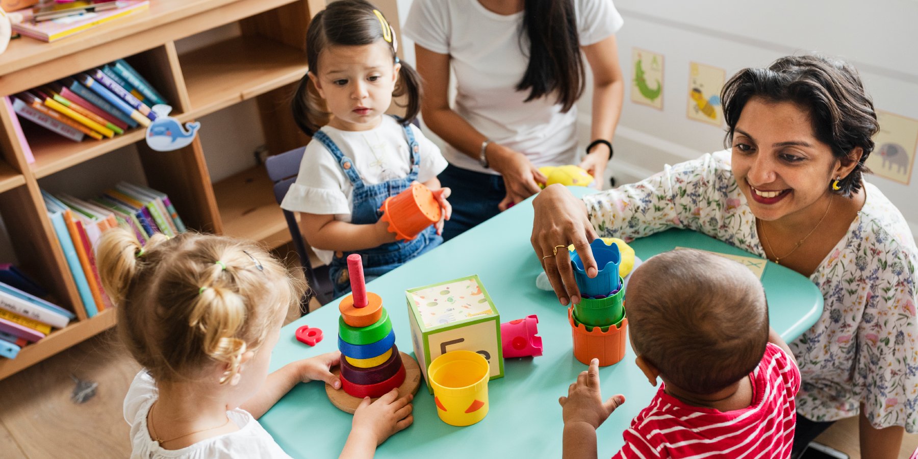 Children and an adult enjoying themselves while playing with things on a table