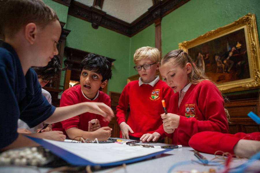 A group of children collaborating on a project at the museum, focused and engaged in their work.