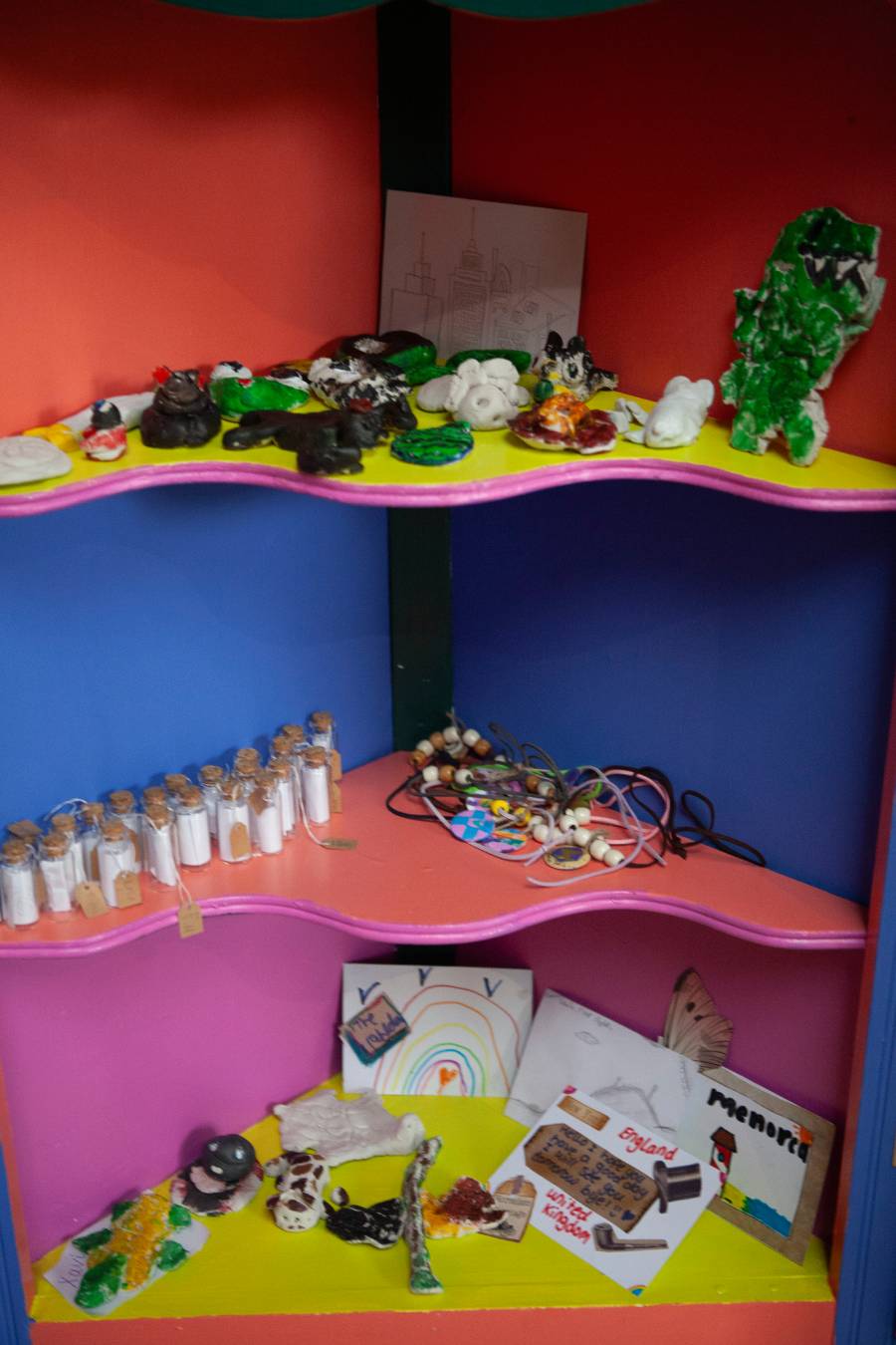 Vibrant shelves displaying a variety of colourful items, including books, plants, and decorative objects.
