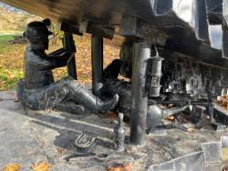 A close up of the two miners working under the sculpture.
