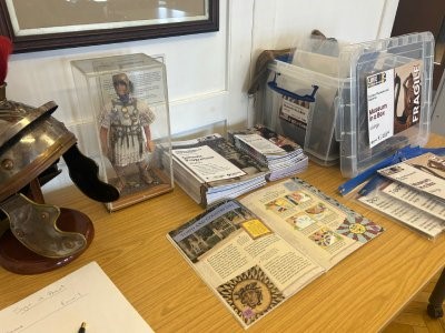 A table displaying various Roman items, books, and a helmet all arranged neatly.