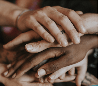 6 multi-cultural hands stacked on top of each other