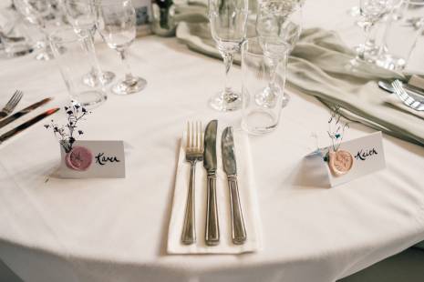 Cutlery and glasses set up at the table for a wedding meal.