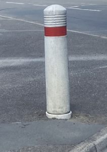 White bollard with a red reflective stripe around the top