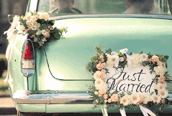 A green car with a sign on it saying just married
