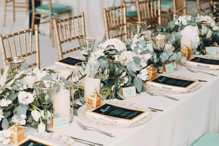 A table laid out with flowers and plates with glasses