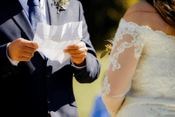 A couple reading vows from a piece of paper