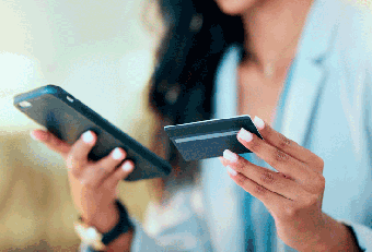 A photo of a person holding a mobile phone and debit card